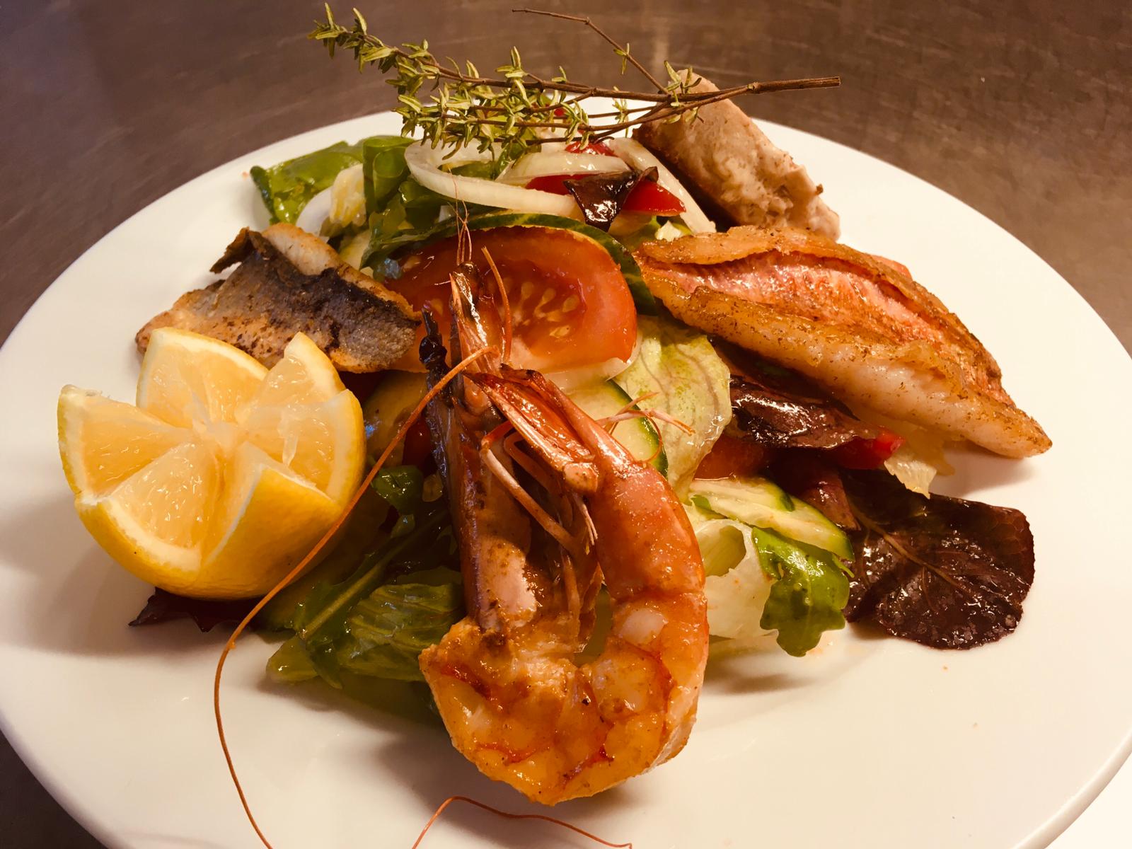 Fischgericht mit Garnelen, Salat und Gemüse