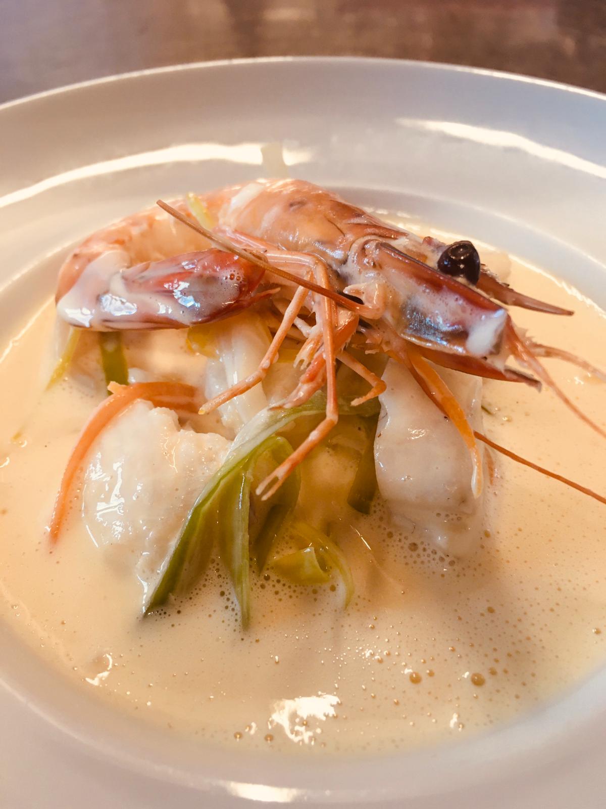 Fischgericht in heller Sauce mit Garnelen und Gemüse